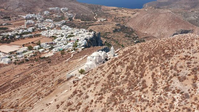 Aerial flying through Panagia Church uphill and Folegandros village Background, Greece