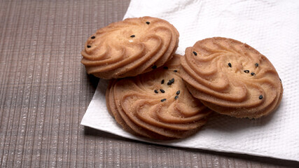 Homemade oatmeal cookies with flax and sesame seeds on white wooden table, copy space. Healthy vegan oat cookies