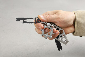 Hand holds wearable lightweight tools on bundle, on gray background close-up