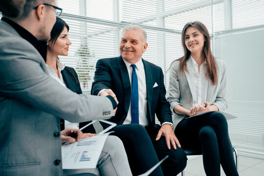 business partners shaking hands after discussing a new contract.