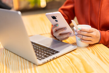 Alternative unrecognizable person with a hot coffee surfing the internet on the computer and...