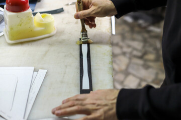 Designer creates a model with tools on the table. Fixing a pattern on the fabric. Tailor is making...