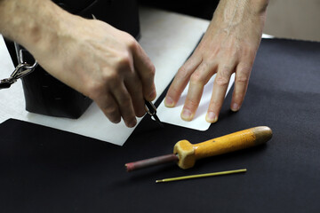 Designer creates a model with tools on the table. Fixing a pattern on the fabric. Tailor is making a bag. Designer creates a model with tools on the table. Top view, flat lay.