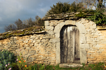 porte ancienne en pierres sur un jardin en Bourgogne