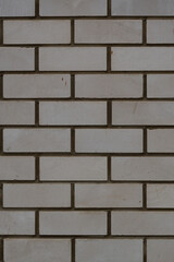 Vertical photo of the background of a white brick wall. The texture of a brick wall made of white silicate brick.