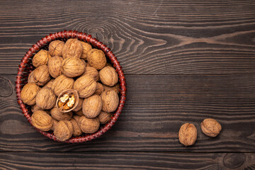 walnuts in a basket on a wooden background top view