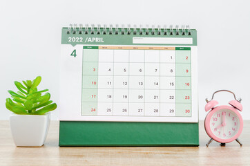 April 2022 desk calendar on wooden table.