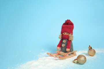 Christmas decoration of a girl on a sleigh rolling in the snow, on a blue background. Happy New Year and Merry Christmas 2022.