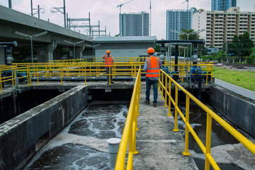 service engineer  checking on waste water treatment plant with pump on background. worker  working...