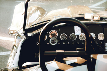 Retro convertible car with interesting dials and knobs on the dashboard.