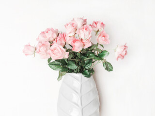 Bouquet of pink roses in ceramic vase.