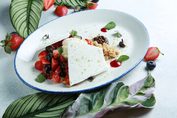 Summer dessert with fresh berries, strawberries, blueberries, biscuit, ice cream and meringue on a white plate on a light gray background. Rustic. Background image, copy space