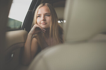 Cute teenage girl in a car, enjoying the ride