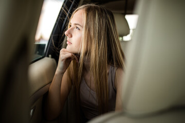 Cute teenage girl in a car, enjoying the ride