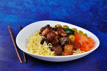 Pieces of fried pork with noodles and vegetables