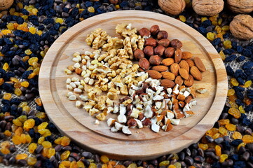 Nut mix. Walnuts, hazelnuts, pine nuts and almonds on a wooden plate.