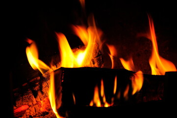 Fireplace with burning wood, at night.