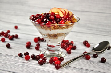 Granola breakfast with yogurt, nuts and berries on a white wooden table. Breakfast time.