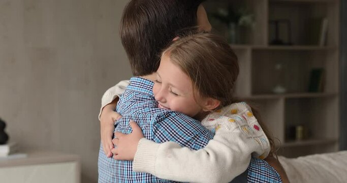 Together again with daddy. Happy kid girl hug beloved father hold on tight to parent meet after being long time apart. Loving preteen adopted daughter embrace neck of caring foster dad at adoption day