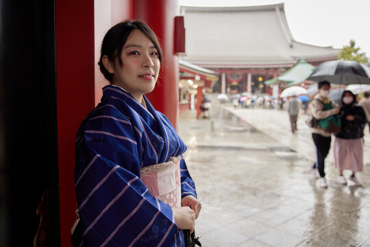 浅草寺の前で微笑む紺の着物を着た日本人女性