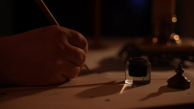a writer writes a letter to a woman. an antique pen. antique paper. letter by candlelight