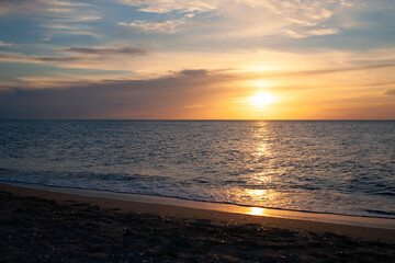 Fototapeta na wymiar Colorful sunset at the sandy beach looking at ocean