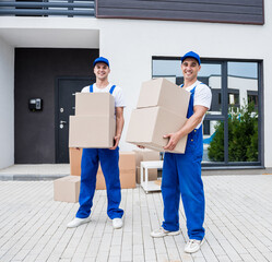 Two removal company workers are loading boxes into a minibus.