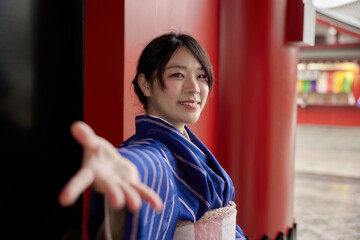 カメラに向かって手を差し出す着物を着た日本人女性