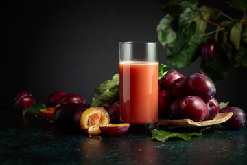 Plum juice and fresh purple plums.
