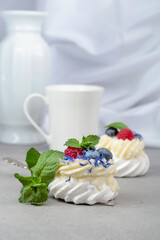 Pavlova dessert with raspberry, blueberry, and mint.