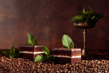 Chocolate cake on a table with coffee beans.