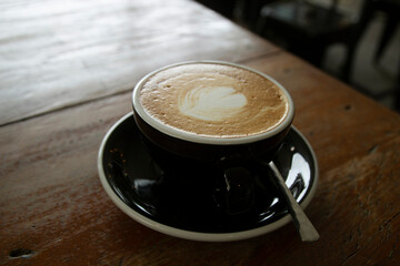 hot coffee cup on wooden table in coffee shop
