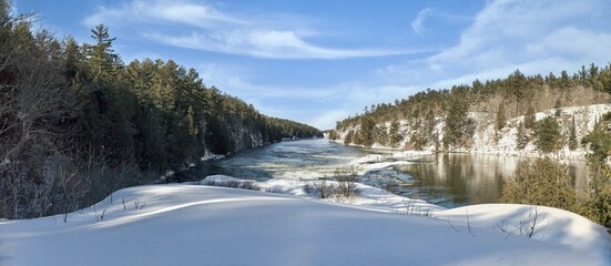 A hike on Recollet Falls trail along French River during winter in provincial park at Killarney, Ont, Canada