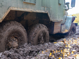Fototapeta na wymiar green Russian Cargo Truck stuck in the mud. Soviet military truck URAL on the road