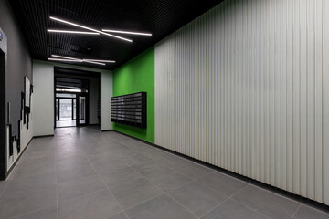 Corridor hall interior, with front door and elevator in many apartment building, with mailboxes with green walls