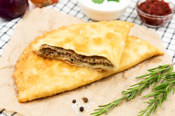 Delicious cheburek with meat and tomato hot sauce. East cuisine meat pastry.