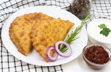 Delicious cheburek with meat and tomato hot sauce. East cuisine meat pastry.