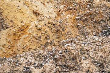 Textural sand, with  relief surface, multi-colored layers and different in size of granules, in outdoor sand career, after mining ore and sand for construction.