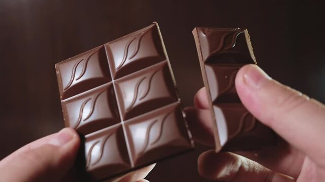 Man breaking a bar of chocolate in slow motion