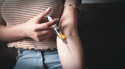 Drug addict with a syringe at home.