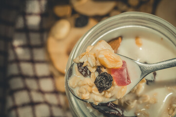 Spoon with oatmeal, yogurt, dried fruits and nuts. Proper nutrition, healthy breakfast. Vertical composition, top view.