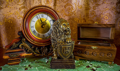 Photo of an old clock, lion and casket on brown background