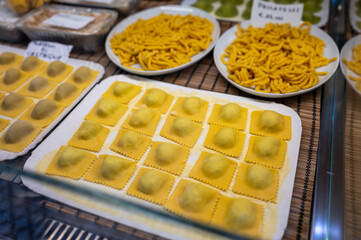 Italian food, fresh home made stuffed pasta tortelli or ravioli dumplings ready to cook, Parma, Emilia Romagna, Italy. Italian names of pasta means ravioli with chesnut and potatoes