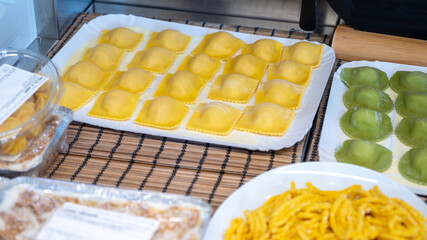 Italian food, fresh home made stuffed pasta tortelli or ravioli dumplings ready to cook, Parma, Emilia Romagna, Italy. Italian names of pasta means ravioli with chesnut and potatoes