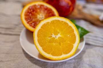 Sicilian sweet juicy yellow and red blood oranges with green leaves close up