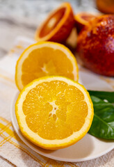 Sicilian sweet juicy yellow and red blood oranges with green leaves close up