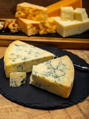 British cheeses collection, blue Stilton, Scottish coloured and English matured cheddar cheeses