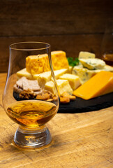 British drinks and food, glasses of Scotch whisky and cheeses collection, blue Stilton, Scottish coloured and English matured cheddar cheeses
