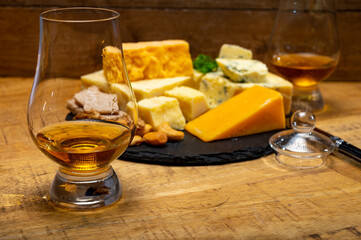 British drinks and food, glasses of Scotch whisky and cheeses collection, blue Stilton, Scottish coloured and English matured cheddar cheeses