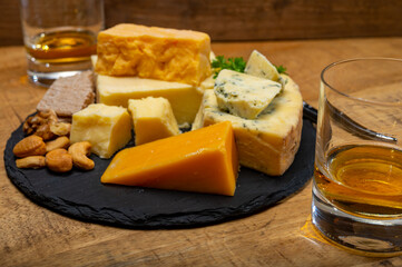 British drinks and food, glasses of Scotch whisky and cheeses collection, blue Stilton, Scottish coloured and English matured cheddar cheeses